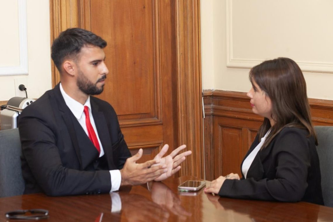 El Dr. Agustín Simonelli conversando con una colega en una reunión de trabajo.